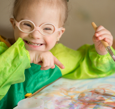 child-smiling-and-painting-creativity